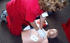 Woman in scrubs practicing CPR