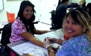 Two women in scrubs smiling