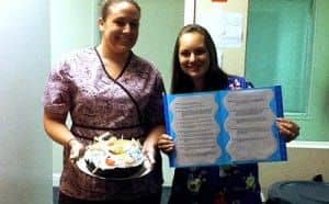 A woman holding a signboard and a woman holding a birthday cake
